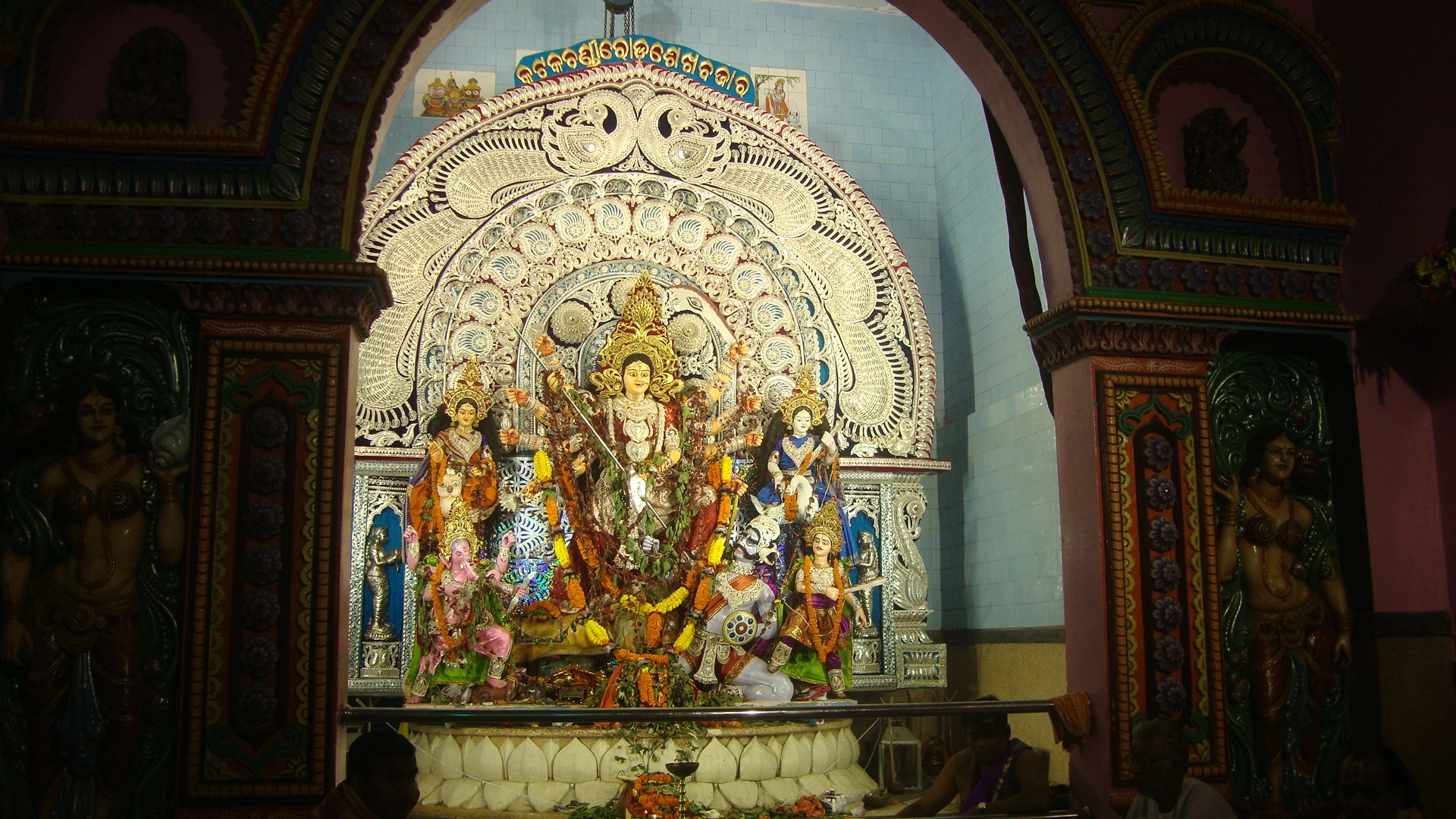 Sheikh Bazar Durga Puja mandap in Kataka showcasing famous peacock pattern silver filigree backdrop