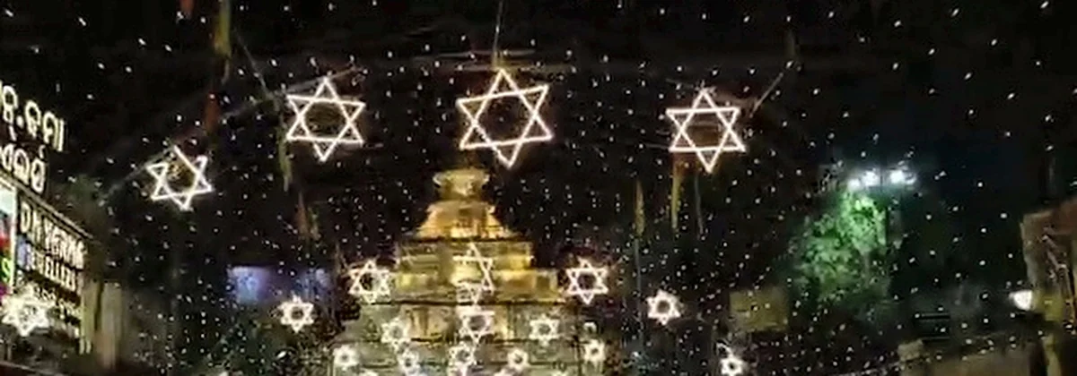 Mahabir Bazar temple replica pandal facade with intricate architectural relief under suspended star lights