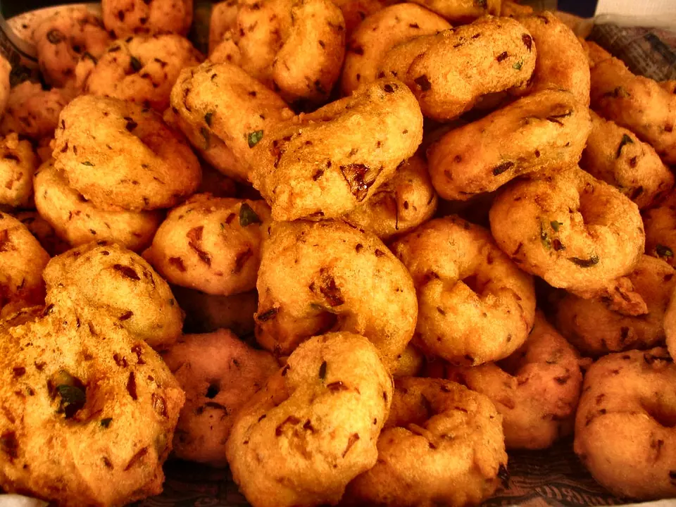 Golden crispy Dhenkanal bara served with spicy yellow peas ghuguni and red garlic chutney