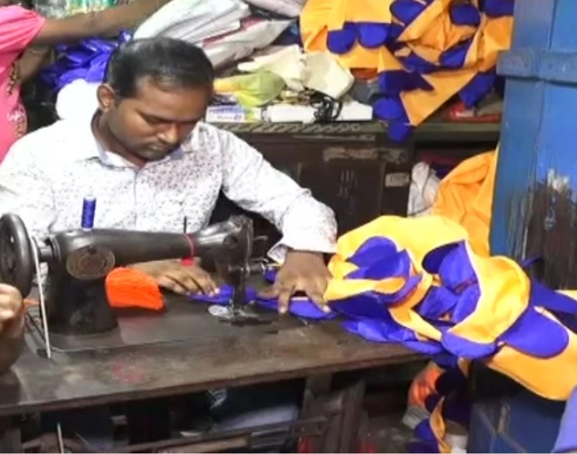 Muslim tailor in Kataka stitching traditional Bhasani Nishan flags for Durga Puja committees reflecting communal harmony