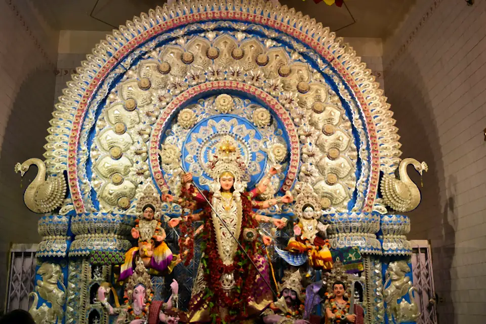 Goddess Durga under an ornate silver-work arch at a Cuttack Durga Puja pandal
